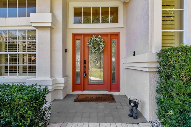 entrance to property featuring stucco siding