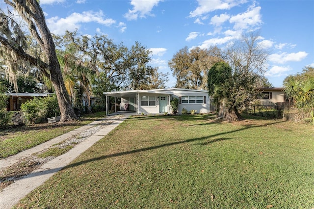 ranch-style home featuring driveway, fence, a front lawn, and an attached carport