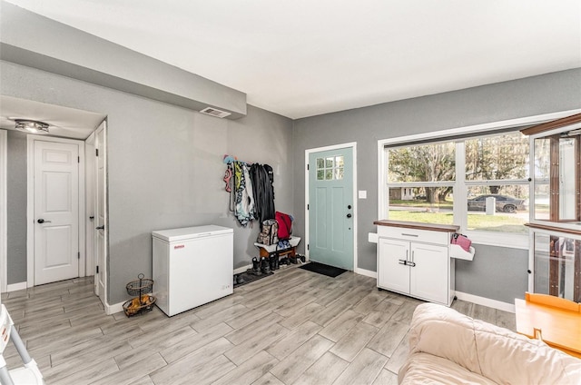 interior space with light wood-style floors, visible vents, and baseboards