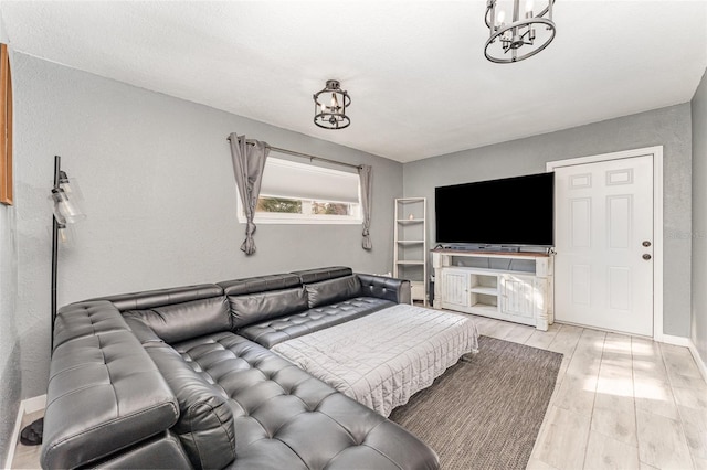 living room featuring light wood-style flooring, a chandelier, and baseboards