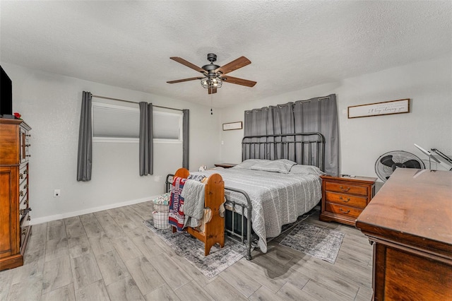 bedroom with light wood-style flooring, baseboards, ceiling fan, and a textured ceiling