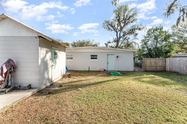 back of house with a yard, a gate, and fence