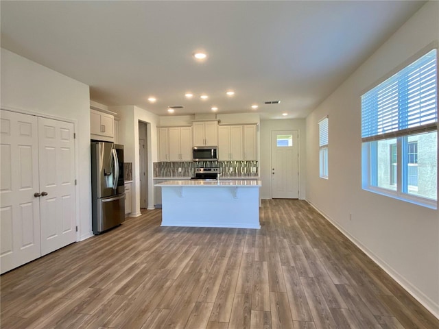 kitchen with tasteful backsplash, visible vents, stainless steel appliances, light countertops, and white cabinetry