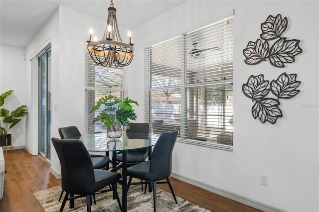 dining area featuring a chandelier, wood finished floors, and baseboards