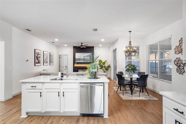 kitchen featuring a sink, visible vents, open floor plan, light countertops, and stainless steel dishwasher