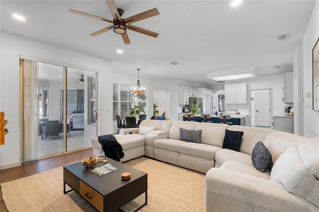 living room with ceiling fan with notable chandelier, recessed lighting, visible vents, and light wood-style floors