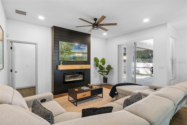 living room featuring recessed lighting, visible vents, a fireplace, and wood finished floors