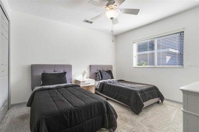 carpeted bedroom with baseboards, visible vents, and a ceiling fan