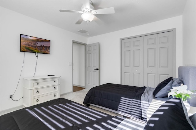 carpeted bedroom featuring a ceiling fan, a closet, visible vents, and baseboards