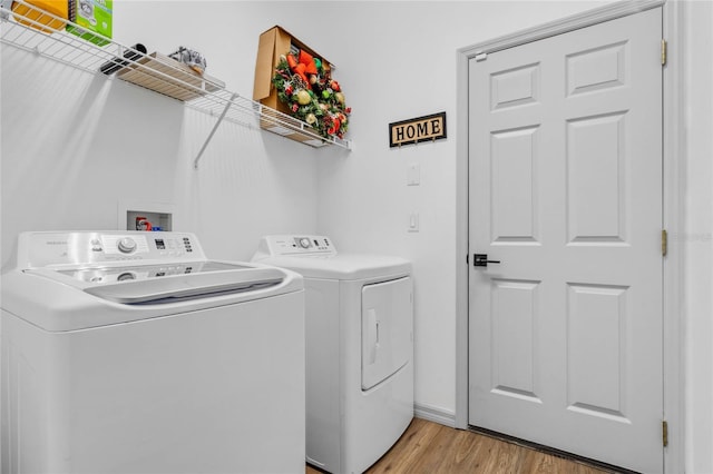 clothes washing area with laundry area, light wood-type flooring, and independent washer and dryer