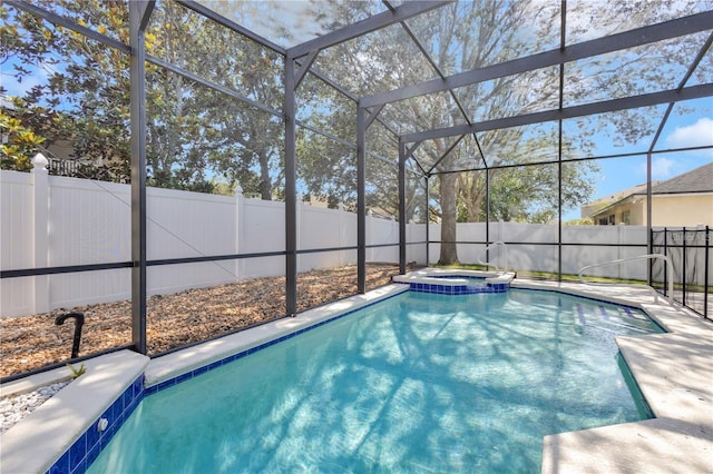 view of swimming pool with a fenced backyard, a pool with connected hot tub, and a lanai