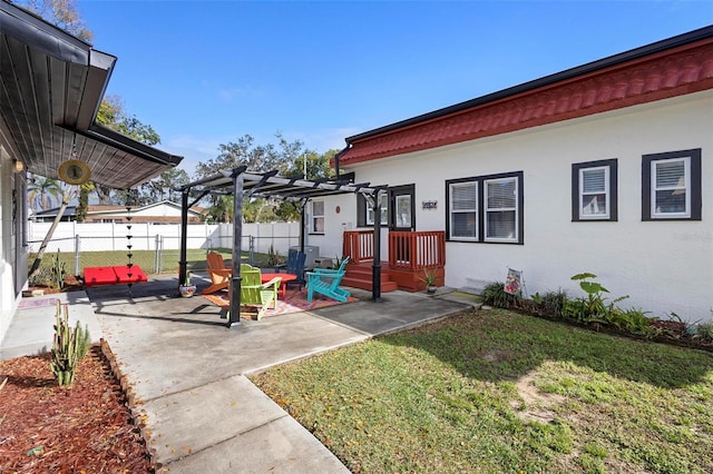 exterior space with fence, a lawn, stucco siding, a pergola, and a patio area