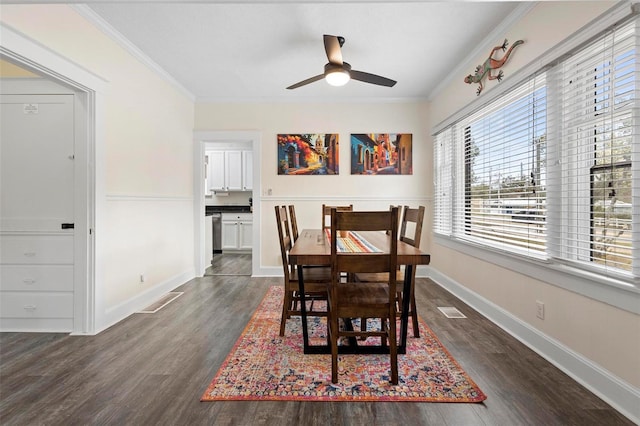 dining space with dark wood-type flooring, visible vents, and crown molding