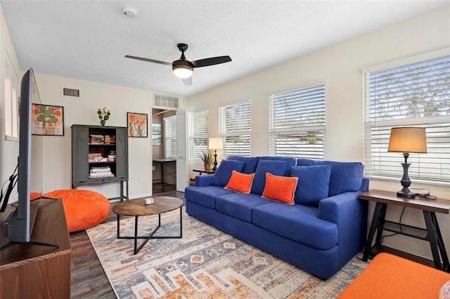 living area with ceiling fan, visible vents, and wood finished floors