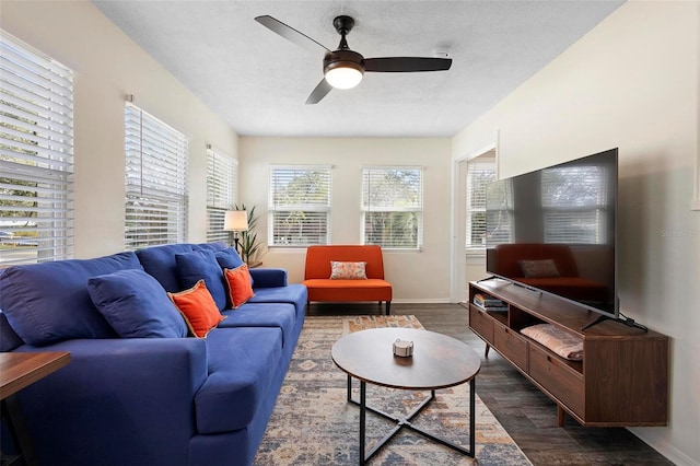 living room with a textured ceiling, ceiling fan, wood finished floors, and baseboards