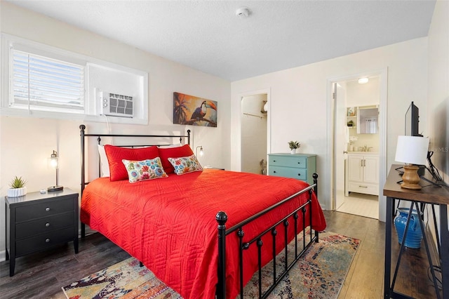 bedroom featuring ensuite bath and wood finished floors