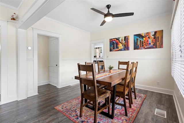 dining area with dark wood-style flooring, crown molding, visible vents, ceiling fan, and baseboards