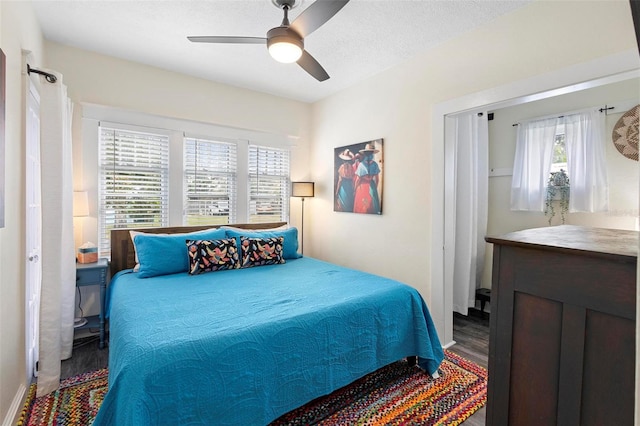 bedroom with ceiling fan, a textured ceiling, and wood finished floors