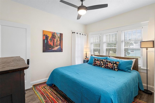 bedroom featuring ceiling fan, baseboards, and wood finished floors