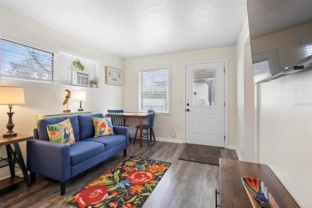 living room with a textured ceiling, wood finished floors, and baseboards