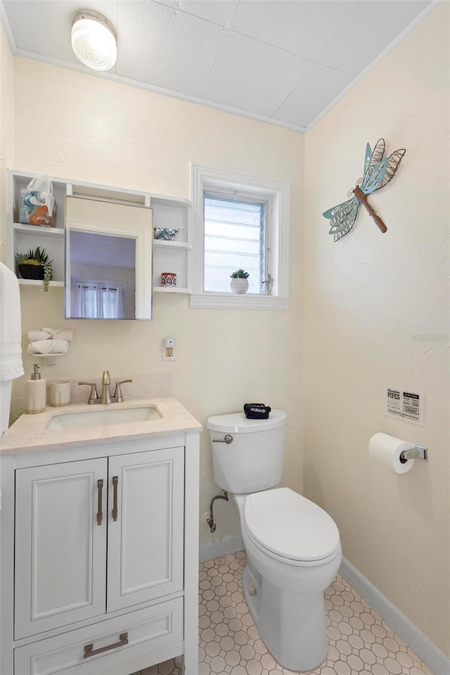 half bath featuring toilet, baseboards, and vanity