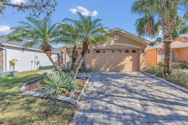 view of front facade featuring an attached garage, decorative driveway, and stucco siding