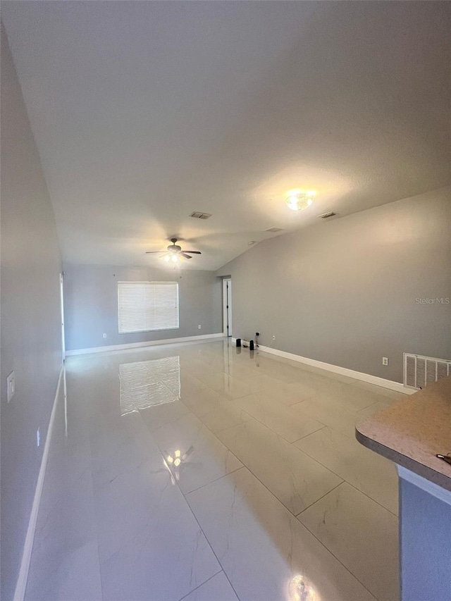 spare room with marble finish floor, a ceiling fan, visible vents, and baseboards