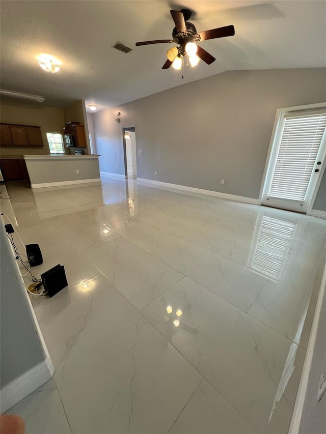 interior space featuring marble finish floor, baseboards, visible vents, and vaulted ceiling