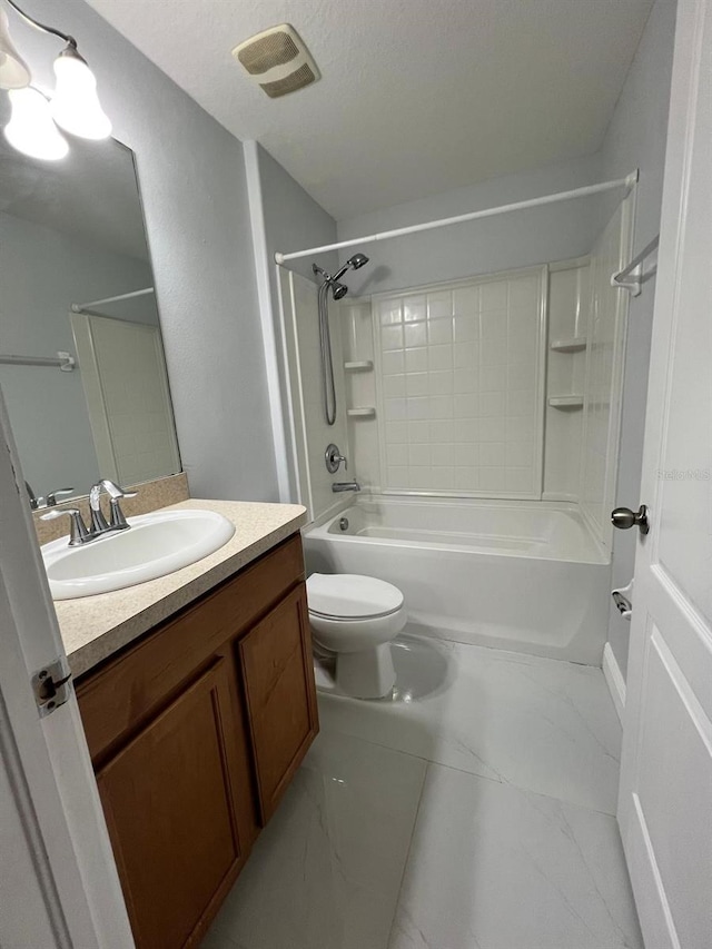 bathroom featuring marble finish floor, shower / bathing tub combination, toilet, vanity, and a textured ceiling