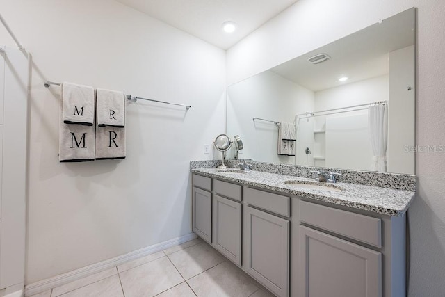 full bathroom featuring double vanity, tile patterned flooring, visible vents, and a sink