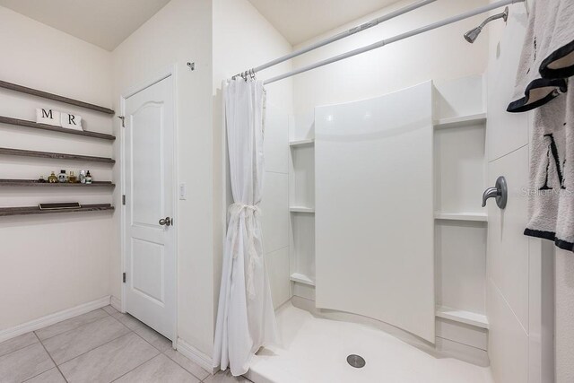 full bath with tile patterned flooring, a shower stall, and baseboards