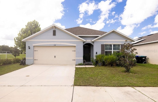 ranch-style house featuring a garage, driveway, a shingled roof, and a front yard