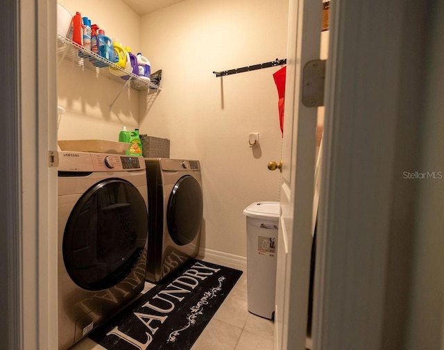 washroom with washer and dryer, laundry area, tile patterned flooring, and baseboards