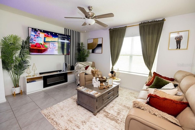 living area featuring ceiling fan, baseboards, and tile patterned floors