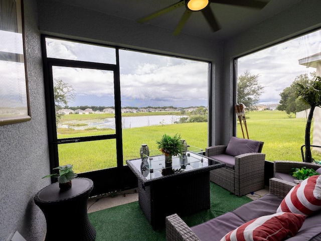 sunroom featuring a water view and ceiling fan