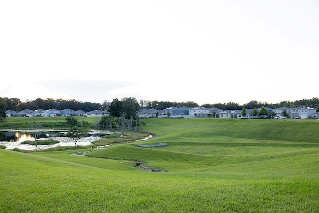 view of community with a water view, a residential view, and a lawn