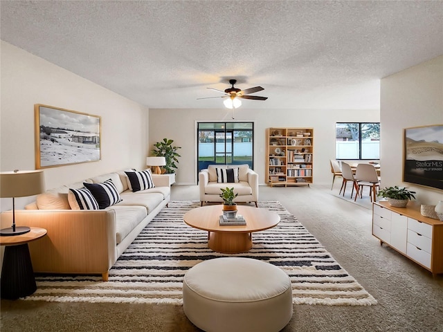 carpeted living room with a textured ceiling and a ceiling fan