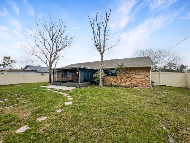 back of property with a patio area, a fenced backyard, a yard, and brick siding