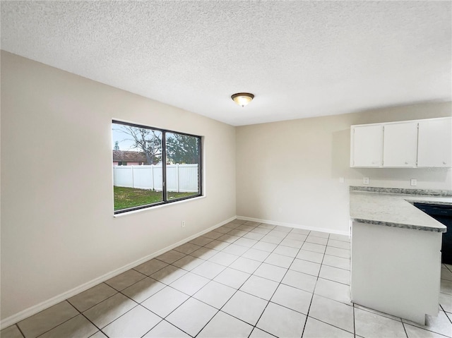 unfurnished living room featuring a textured ceiling, baseboards, and light tile patterned floors