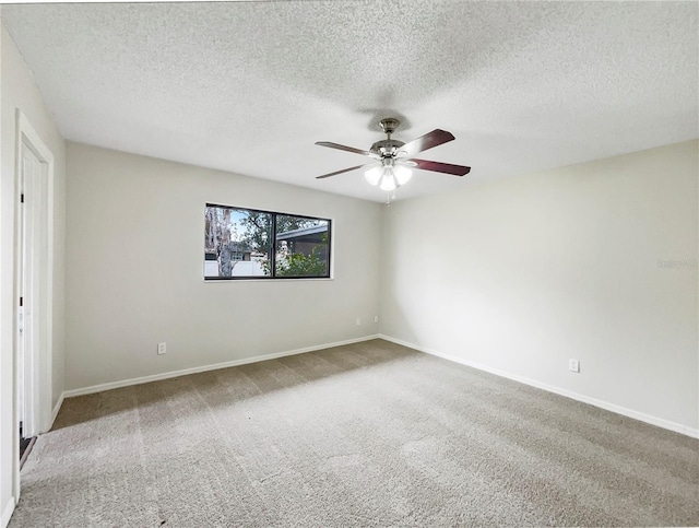 carpeted spare room featuring a ceiling fan, a textured ceiling, and baseboards