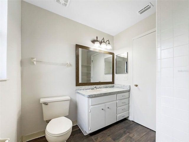 bathroom with visible vents, vanity, toilet, and wood finished floors