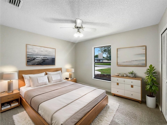 bedroom with light carpet, visible vents, and a textured ceiling