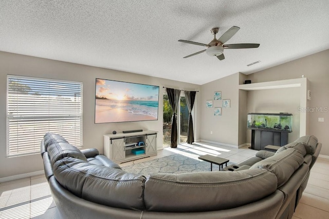 living room featuring visible vents, a ceiling fan, vaulted ceiling, a textured ceiling, and light tile patterned flooring