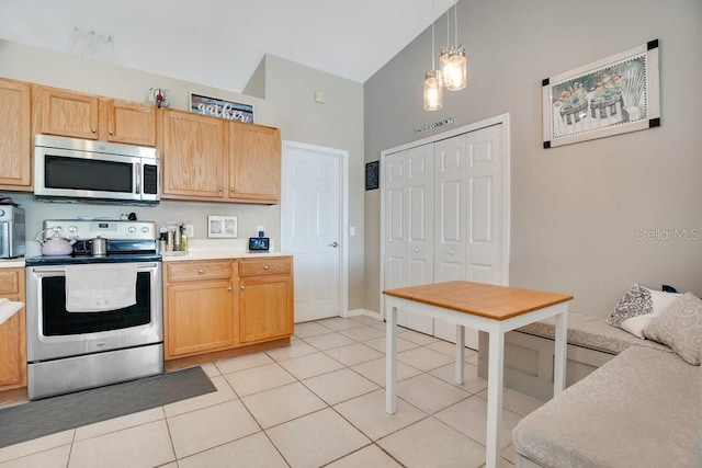 kitchen with light tile patterned floors, stainless steel appliances, light countertops, and decorative light fixtures