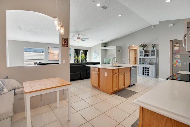 kitchen featuring arched walkways, stainless steel dishwasher, open floor plan, vaulted ceiling, and a sink