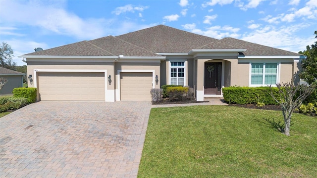 ranch-style home featuring an attached garage, a front lawn, decorative driveway, and stucco siding