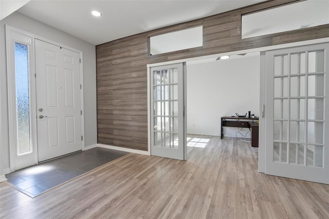 foyer featuring baseboards, wood finished floors, and french doors