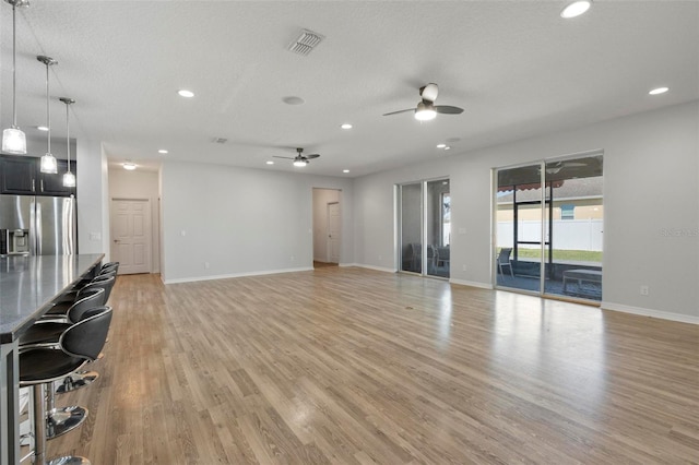 unfurnished living room featuring light wood-style flooring, visible vents, and recessed lighting