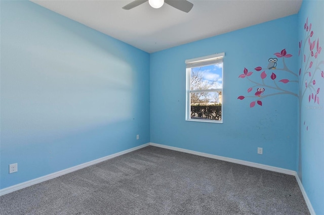 carpeted spare room featuring ceiling fan and baseboards