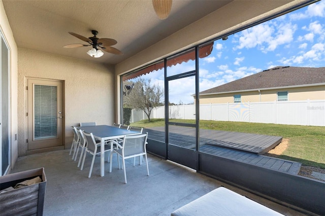 sunroom / solarium with a ceiling fan